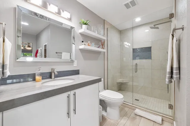 a bathroom with a sink a toilet and shower