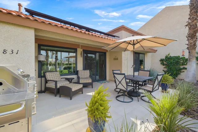 a view of patio with table and chairs under an umbrella