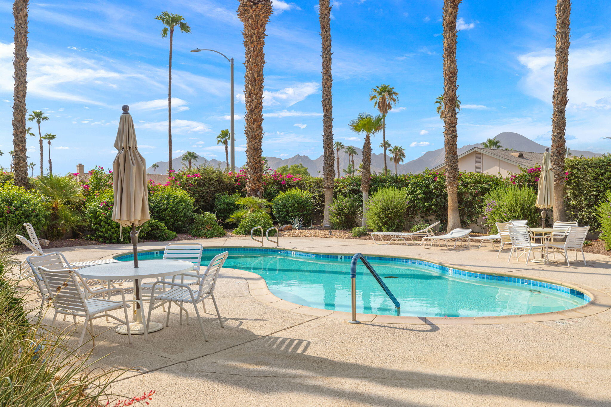 42831 Scirocco Road Palm Desert, CA 92211 - Photo 20 of 32 a view of a swimming pool with a lawn chairs and couches