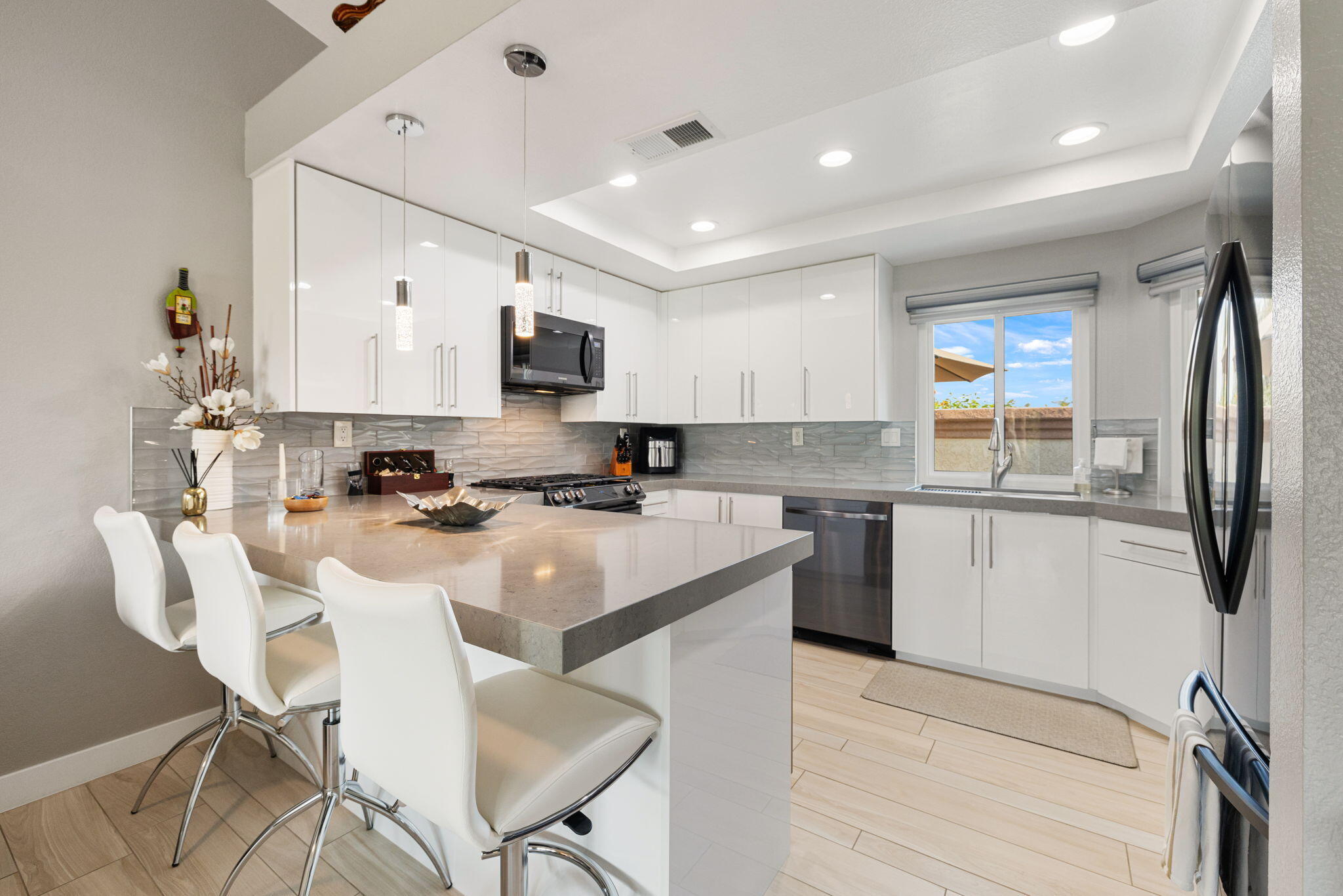 42831 Scirocco Road Palm Desert, CA 92211 - Photo 2 of 32 a kitchen with stainless steel appliances granite countertop a sink a stove a refrigerator cabinets and a dining table with chairs