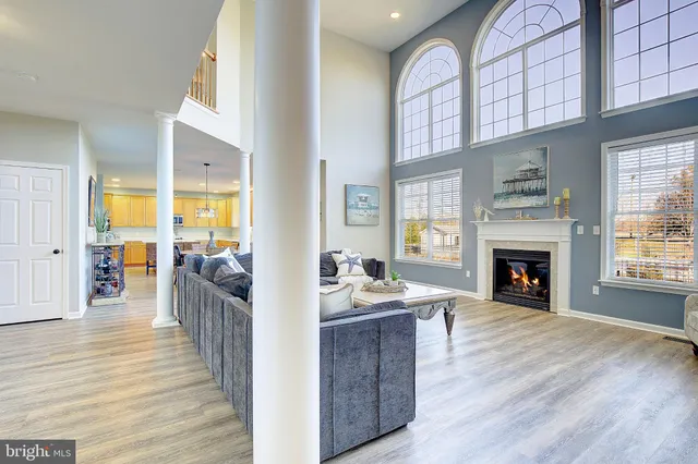 a view of a dining room and livingroom with furniture wooden floor a chandelier