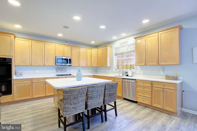 a kitchen with a sink dishwasher and a stove with wooden floor