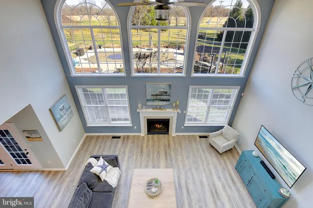 a spacious bedroom with a bed a chandelier and dresser