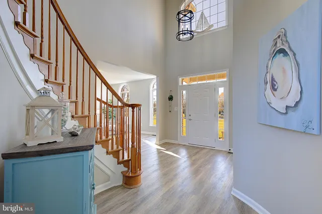 a dining room with furniture a chandelier and wooden floor