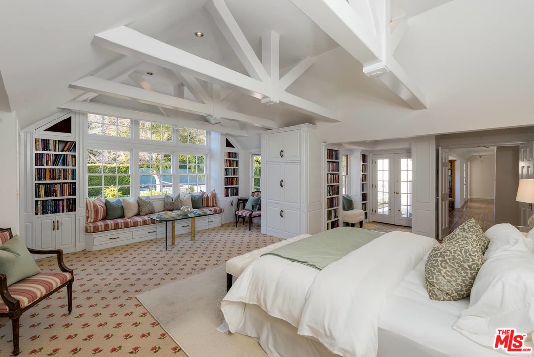 1027 Summit Drive Beverly Hills, CA 90210 - Photo 13 of 23 a spacious bedroom with a bed a table and chair