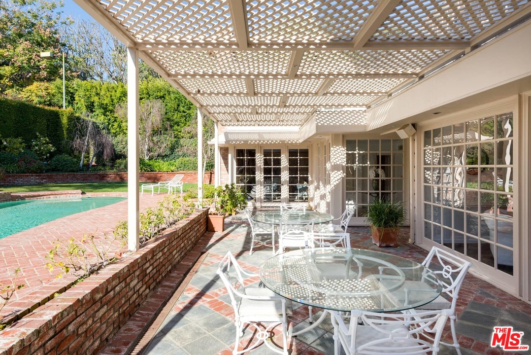 1027 Summit Drive Beverly Hills, CA 90210 - Photo 22 of 23 a roof deck with table and chairs and potted plants