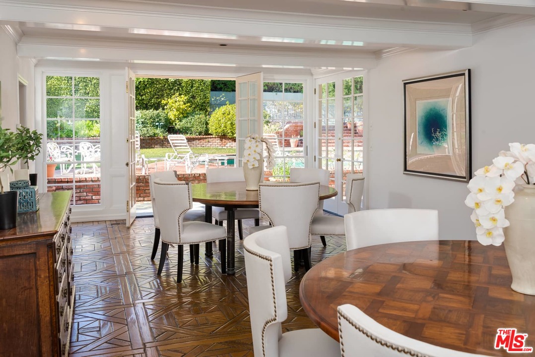 1027 Summit Drive Beverly Hills, CA 90210 - Photo 9 of 23 a dining room with furniture window outside view and wooden floor