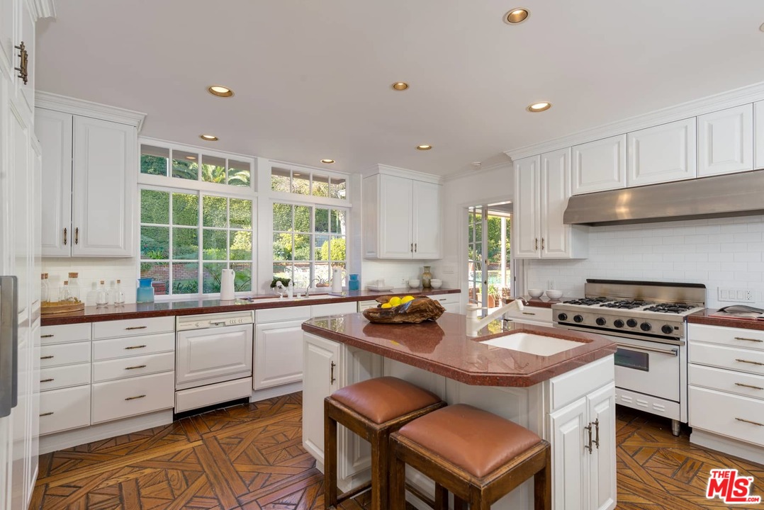 1027 Summit Drive Beverly Hills, CA 90210 - Photo 10 of 23 a kitchen with stainless steel appliances granite countertop a stove a sink and a refrigerator