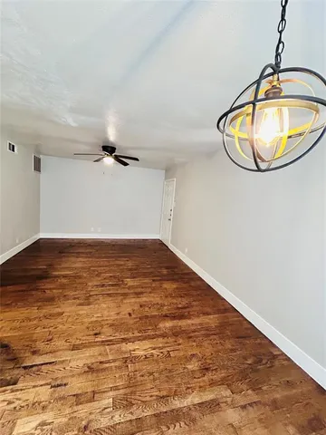 en empty room with wooden floor and mirror