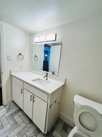 a bathroom with a toilet a sink and mirror