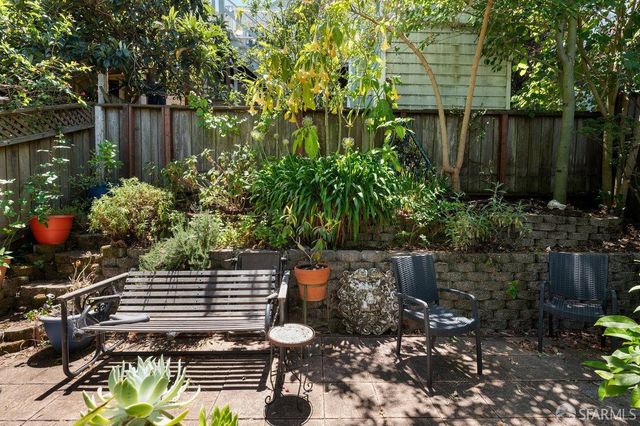 a view of a backyard with plants and a bench