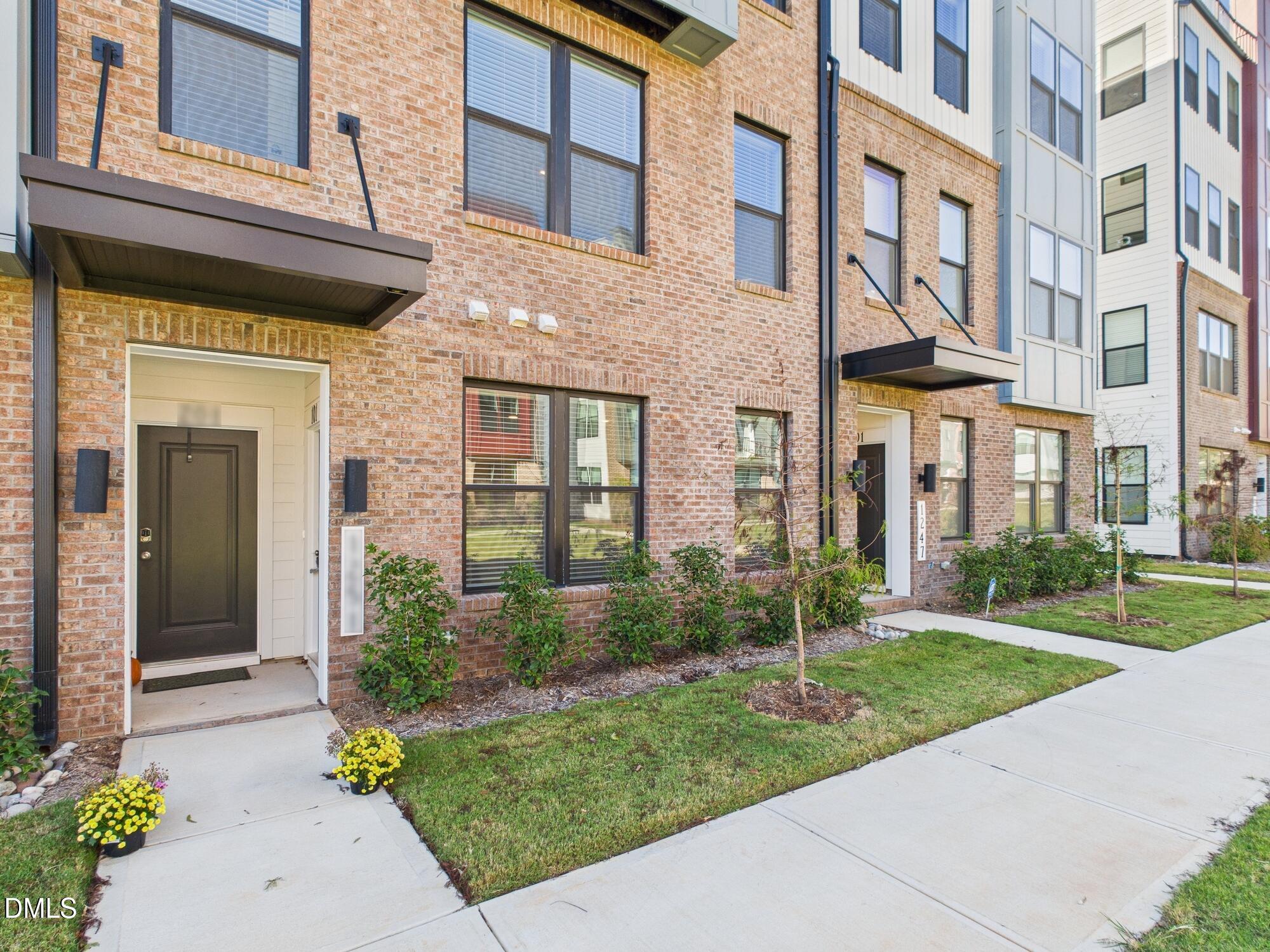 front view of a brick house with a yard