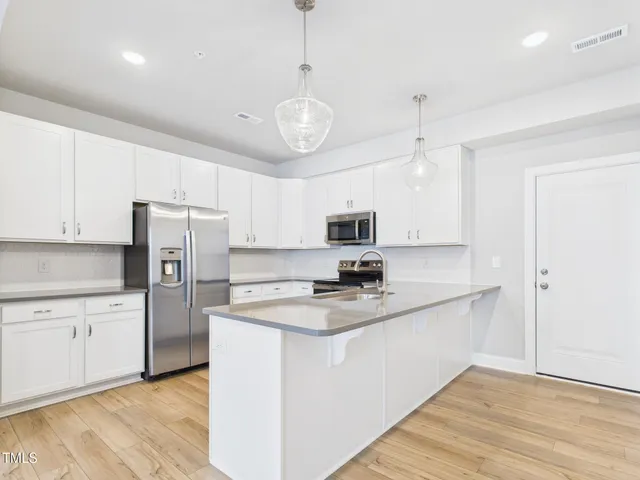 a kitchen with cabinets and wooden floor