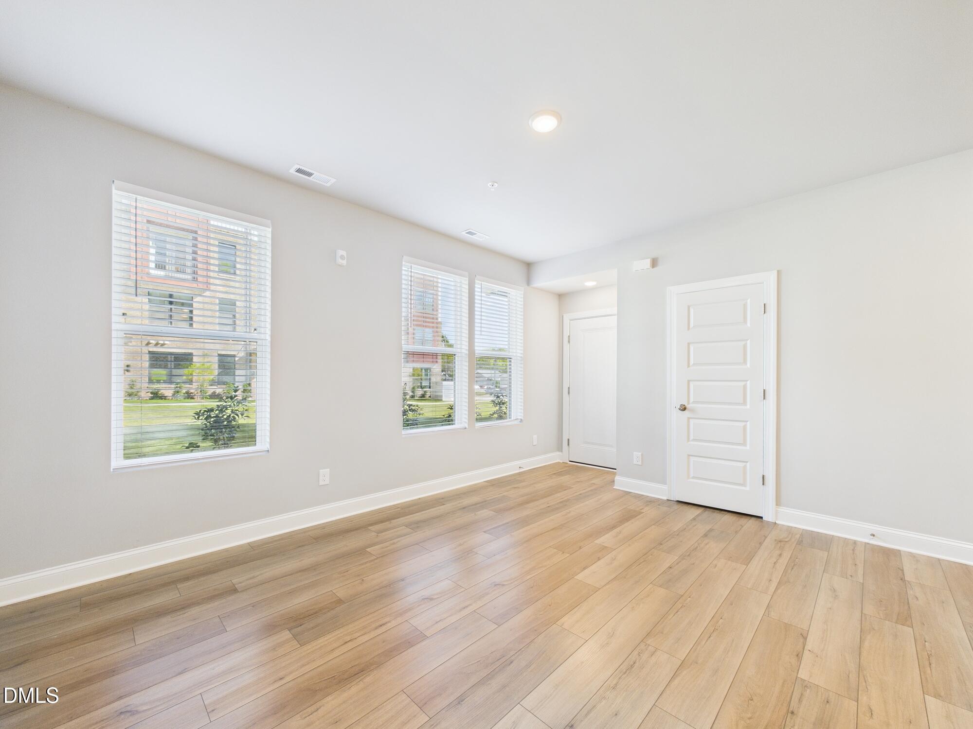 1251 Shaw View Alley, Unit 101 Raleigh, NC 27601 - Photo 10 of 47 an empty room with wooden floor and windows