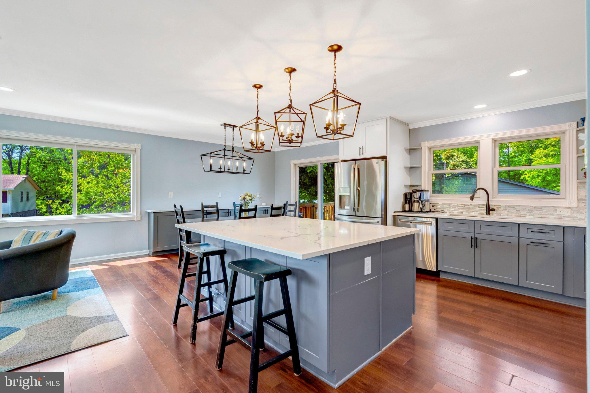 7212 Galgate Drive Springfield, VA 22153 - Photo 2 of 39 a view of a kitchen with kitchen island a large counter top space a sink stainless steel appliances and living room view