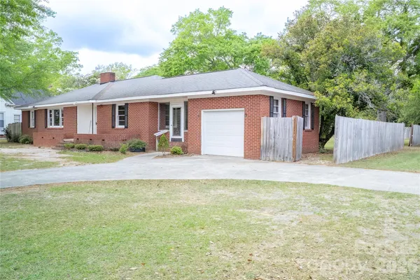 a front view of house with yard and trees in the background