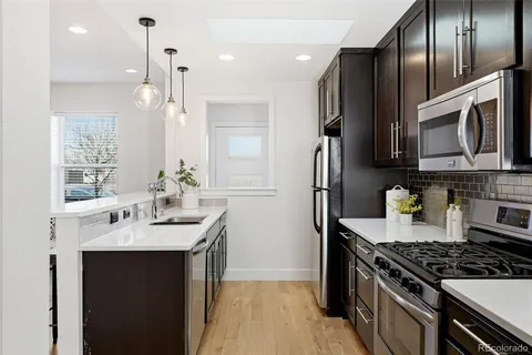 a kitchen with stainless steel appliances granite countertop a sink stove and refrigerator