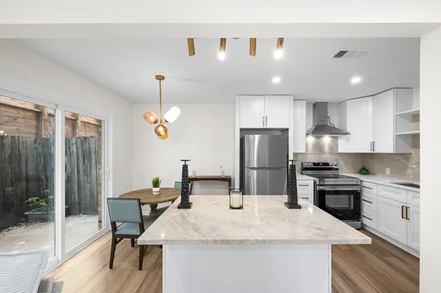 a kitchen with stainless steel appliances a stove a sink and a refrigerator