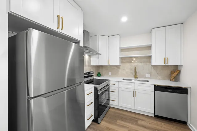 a kitchen with stainless steel appliances a refrigerator sink and cabinets