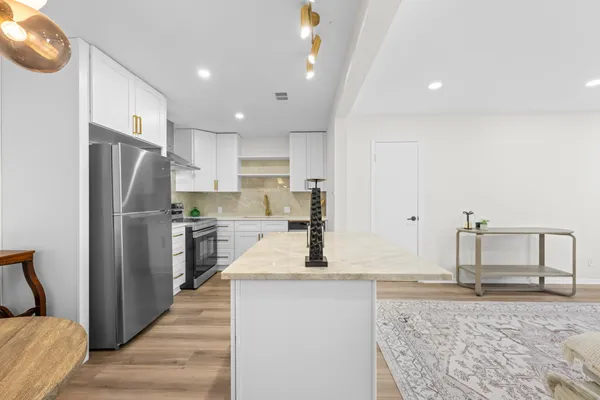 a kitchen with stainless steel appliances a stove a sink and a refrigerator