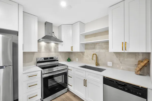 a kitchen with stainless steel appliances kitchen island a table chairs in it and wooden floors