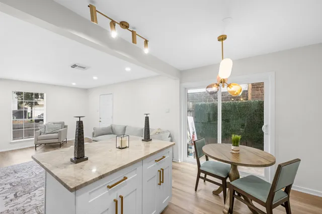 a kitchen with a table chairs and a wooden floor