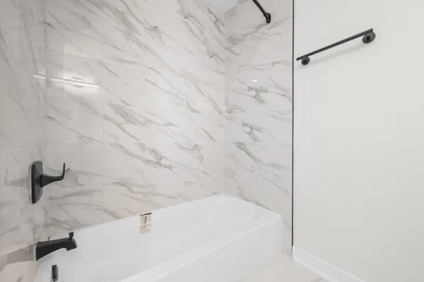 a bedroom with a bed and a flat tv screen on a dresser