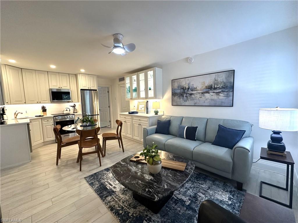 175 5th Avenue South, Unit 103 Naples, FL 34102 - Photo 1 of 18 a living room with furniture kitchen and a table