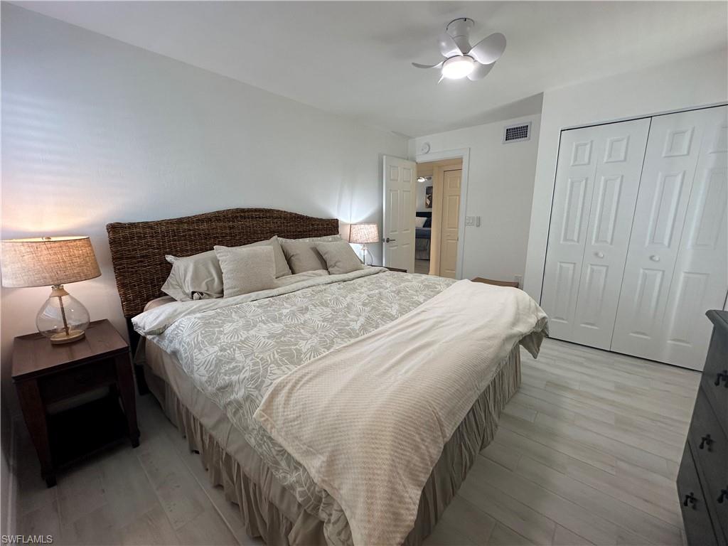 175 5th Avenue South, Unit 103 Naples, FL 34102 - Photo 13 of 18 a bedroom with bed and a night stand