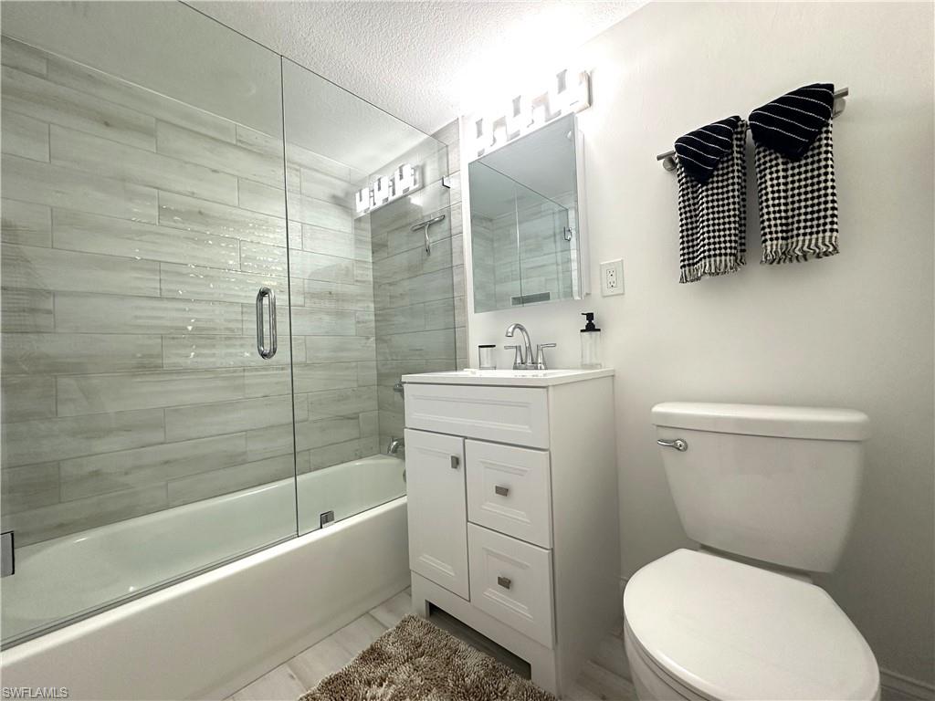 175 5th Avenue South, Unit 103 Naples, FL 34102 - Photo 14 of 18 a bathroom with a toilet sink vanity tub and shower