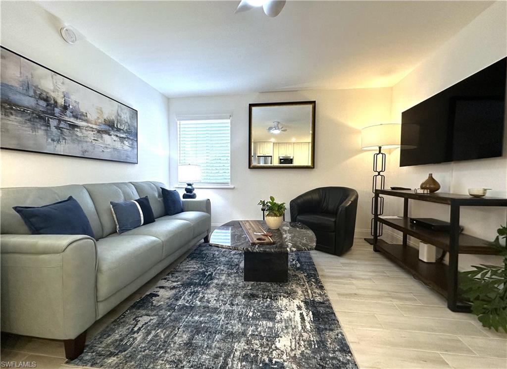 175 5th Avenue South, Unit 103 Naples, FL 34102 - Photo 3 of 18 a living room with furniture and a flat screen tv