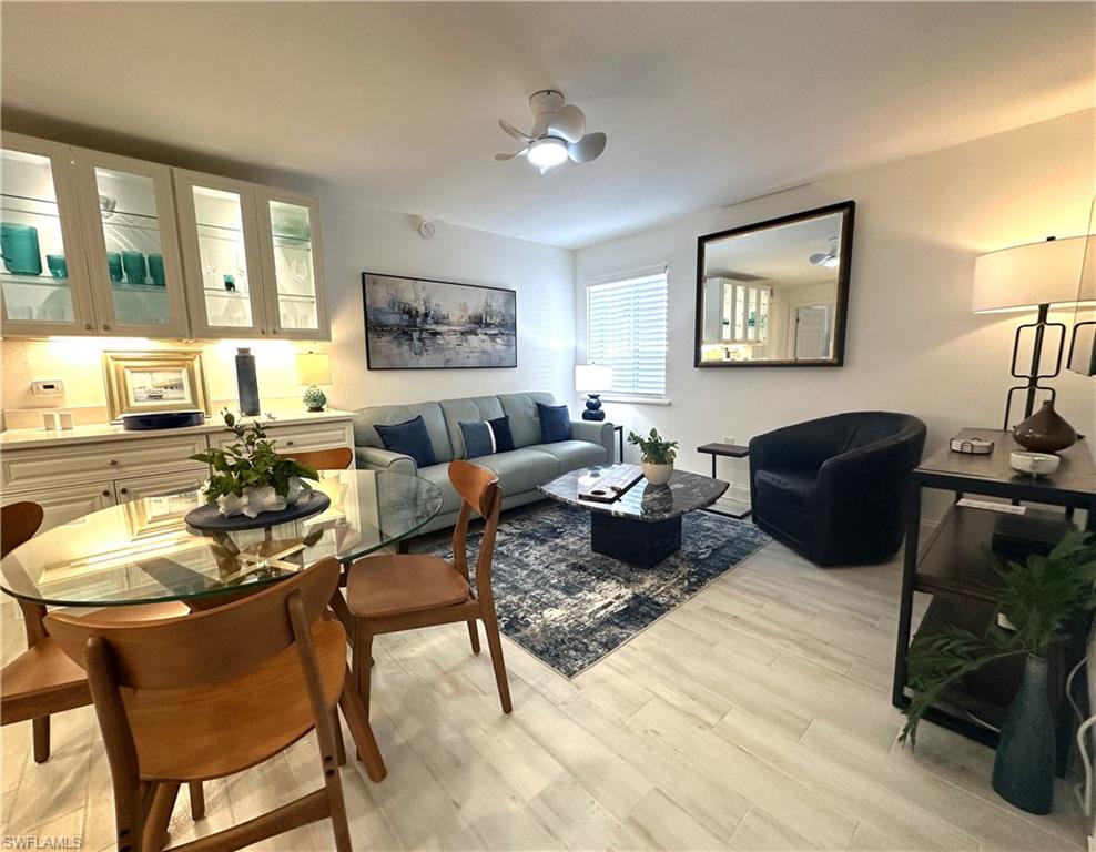 175 5th Avenue South, Unit 103 Naples, FL 34102 - Photo 6 of 18 a living room with furniture a rug and a window