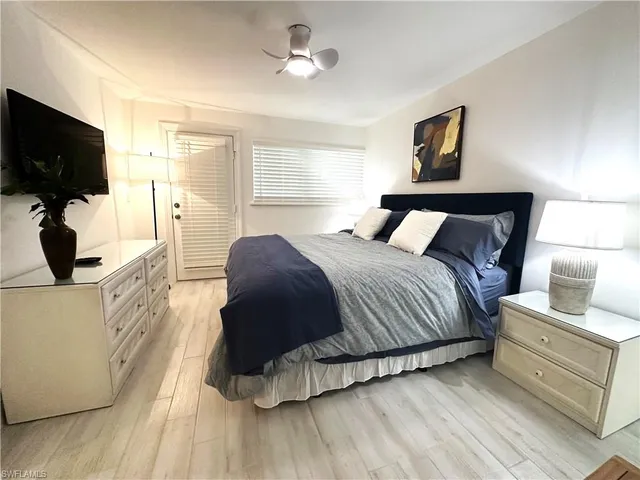 a bedroom with a bed a flat screen tv and dresser