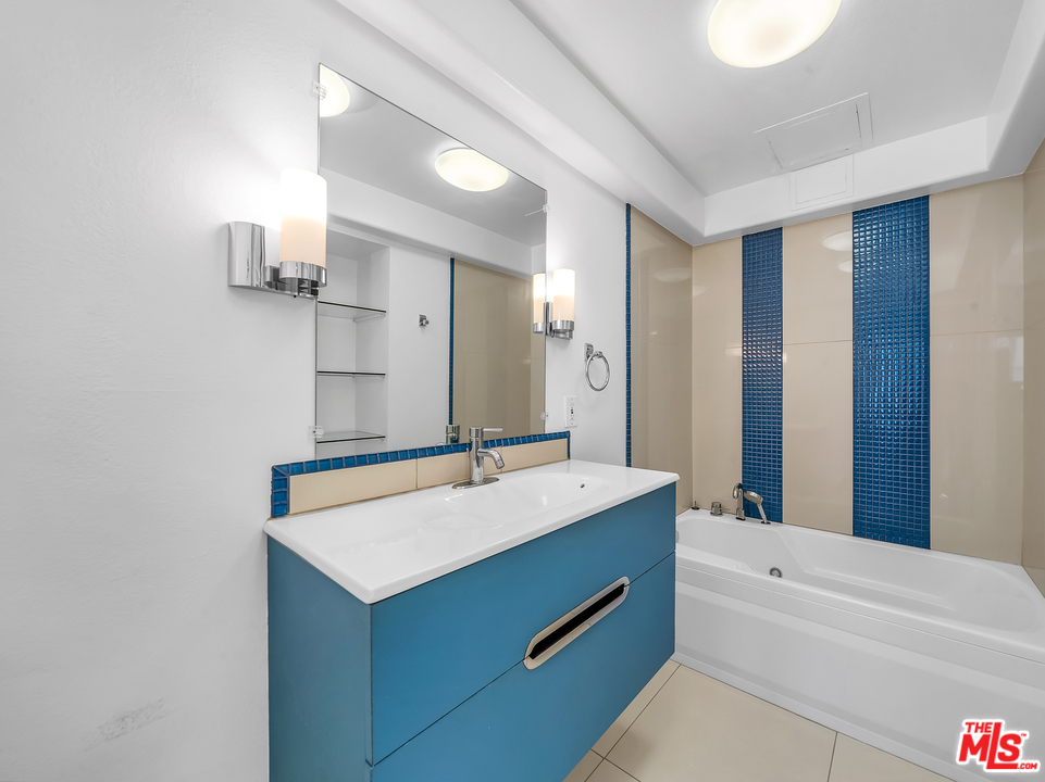 615 Esplanade, Unit 401 Redondo Beach, CA 90277 - Photo 16 of 19 a bathroom with a sink a mirror and a bathtub