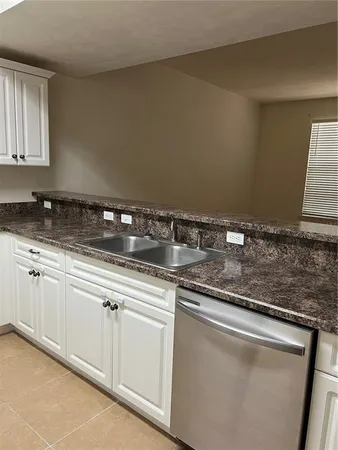 a kitchen with granite countertop a sink and cabinets