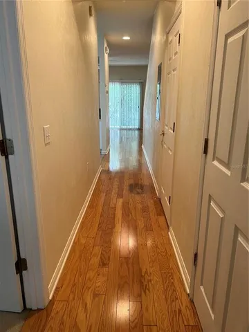 a view of a hallway with wooden floor