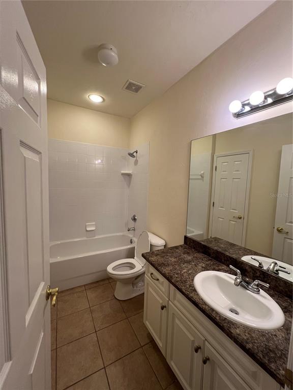 1569 Northwest 29 Road, Unit 3 Gainesville, FL 32605 - Photo 10 of 14 a bathroom with a granite countertop sink toilet mirror and bathtub