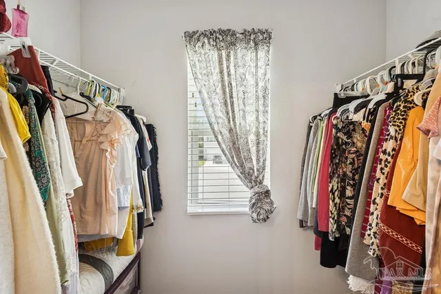 a view of walk in closet with clothes and shoes