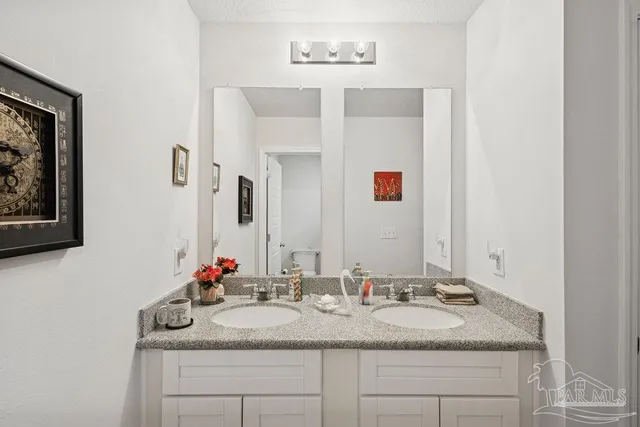 a bathroom with a granite countertop sink and a mirror