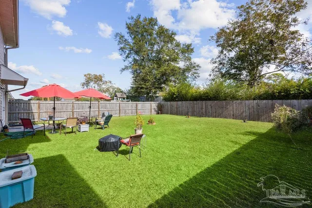 a view of backyard with swimming pool and green space