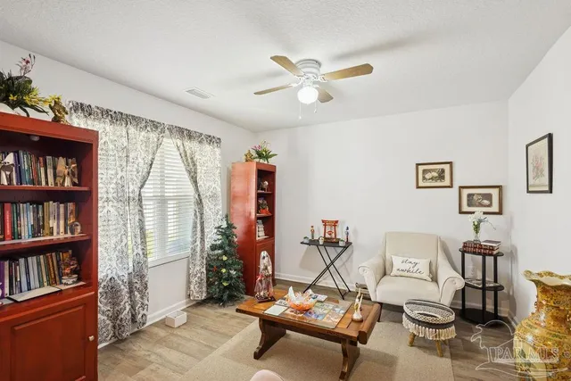 a living room with furniture a bookshelf and a window