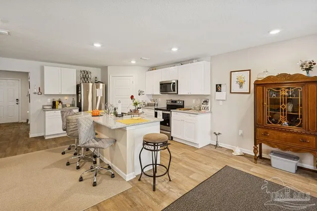 a living room with stainless steel appliances kitchen island granite countertop furniture and a livingroom view