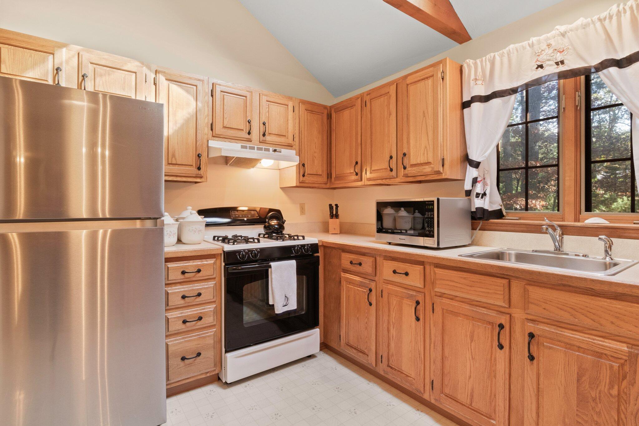 196 Eisenhower Drive Cotuit, MA 02635 - Photo 11 of 33 a kitchen with granite countertop a refrigerator stove top oven and sink