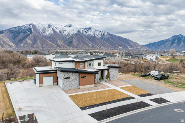 262 North Santa Fe Drive Mapleton, UT 84664 - Photo 2 of 28 View of front of property with stone siding, a mountain view, a residential view, concrete driveway, and an attached garage