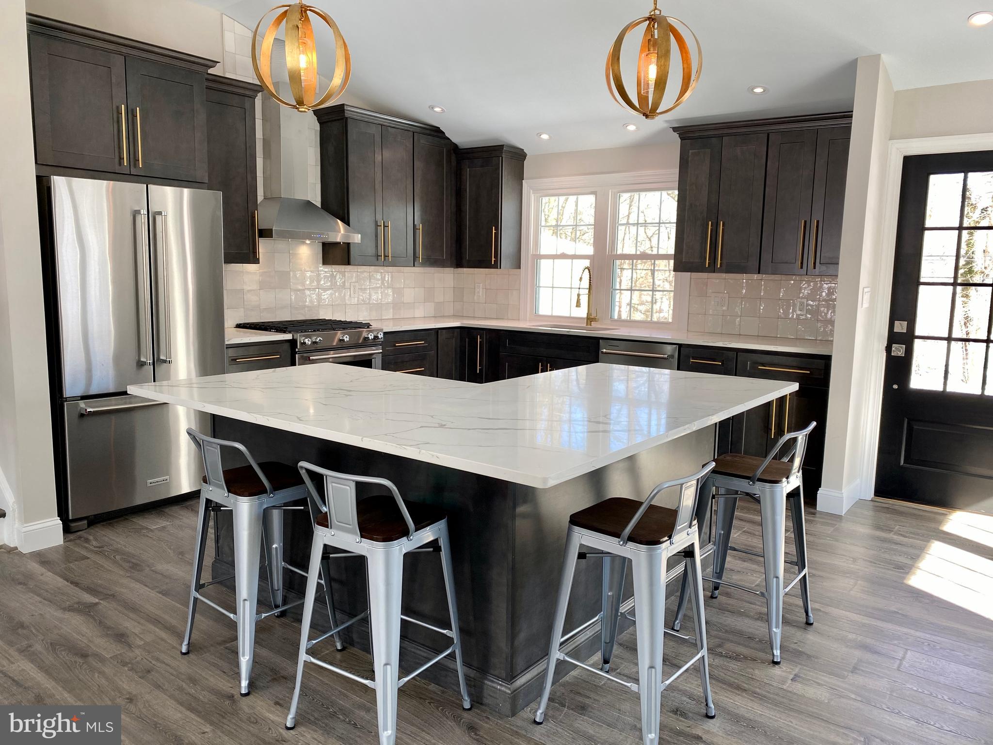 2417 Shellpot Drive Wilmington, DE 19803 - Photo 2 of 18 a kitchen with stainless steel appliances a table chairs refrigerator and microwave