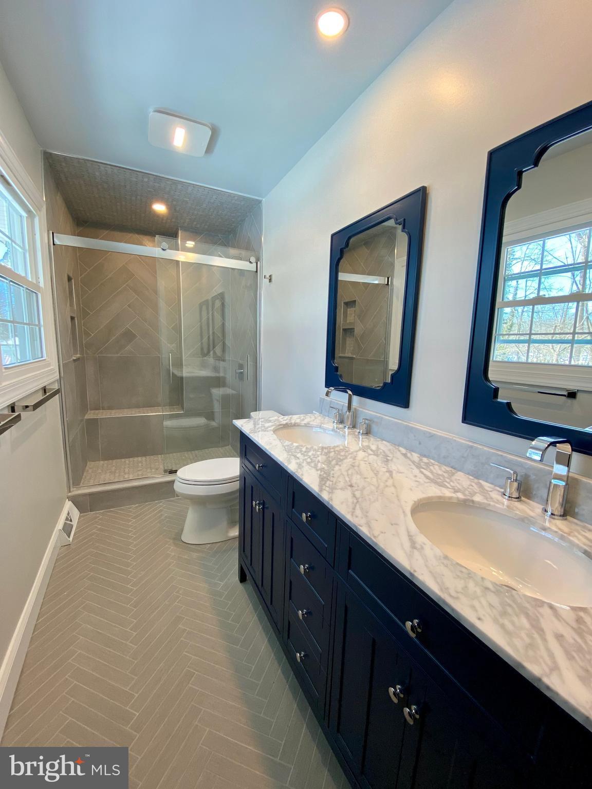 2417 Shellpot Drive Wilmington, DE 19803 - Photo 14 of 18 a bathroom with a double vanity sink toilet mirror and shower