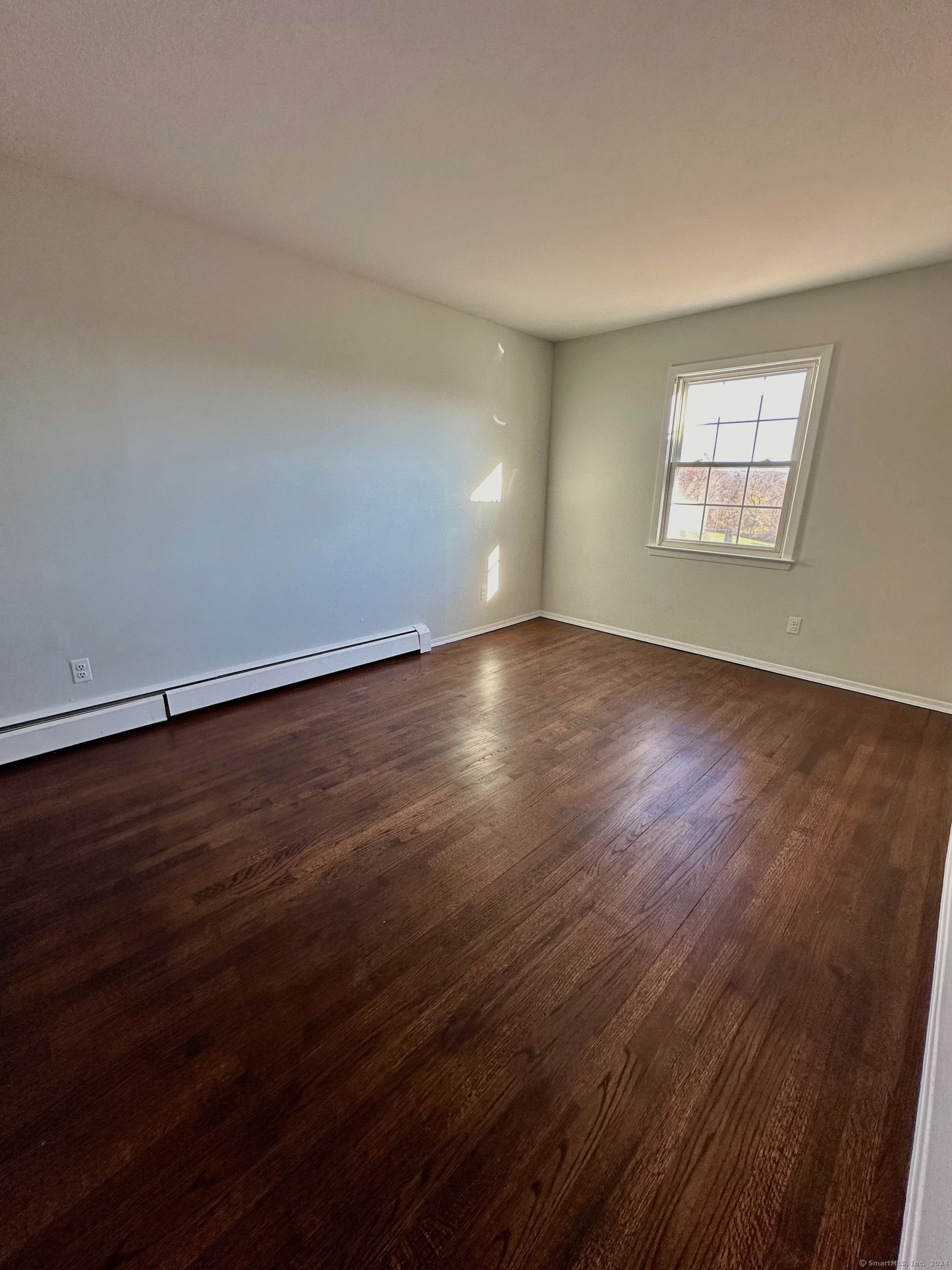 15 Pilgrim Trail, Unit B6 Woodbury, CT 06798 - Photo 4 of 7 an empty room with wooden floor and windows