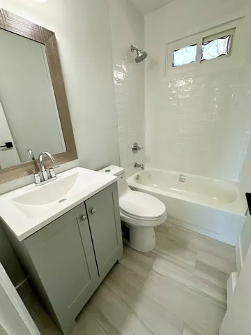 a bathroom with a sink toilet a mirror and shower