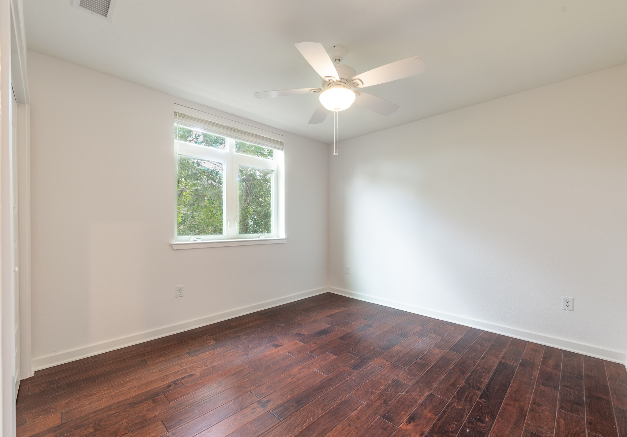 6700 Menchaca Road, Unit 24 Austin, TX 78745 - Photo 4 of 18 Unfurnished room featuring dark wood-style floors and ceiling fan