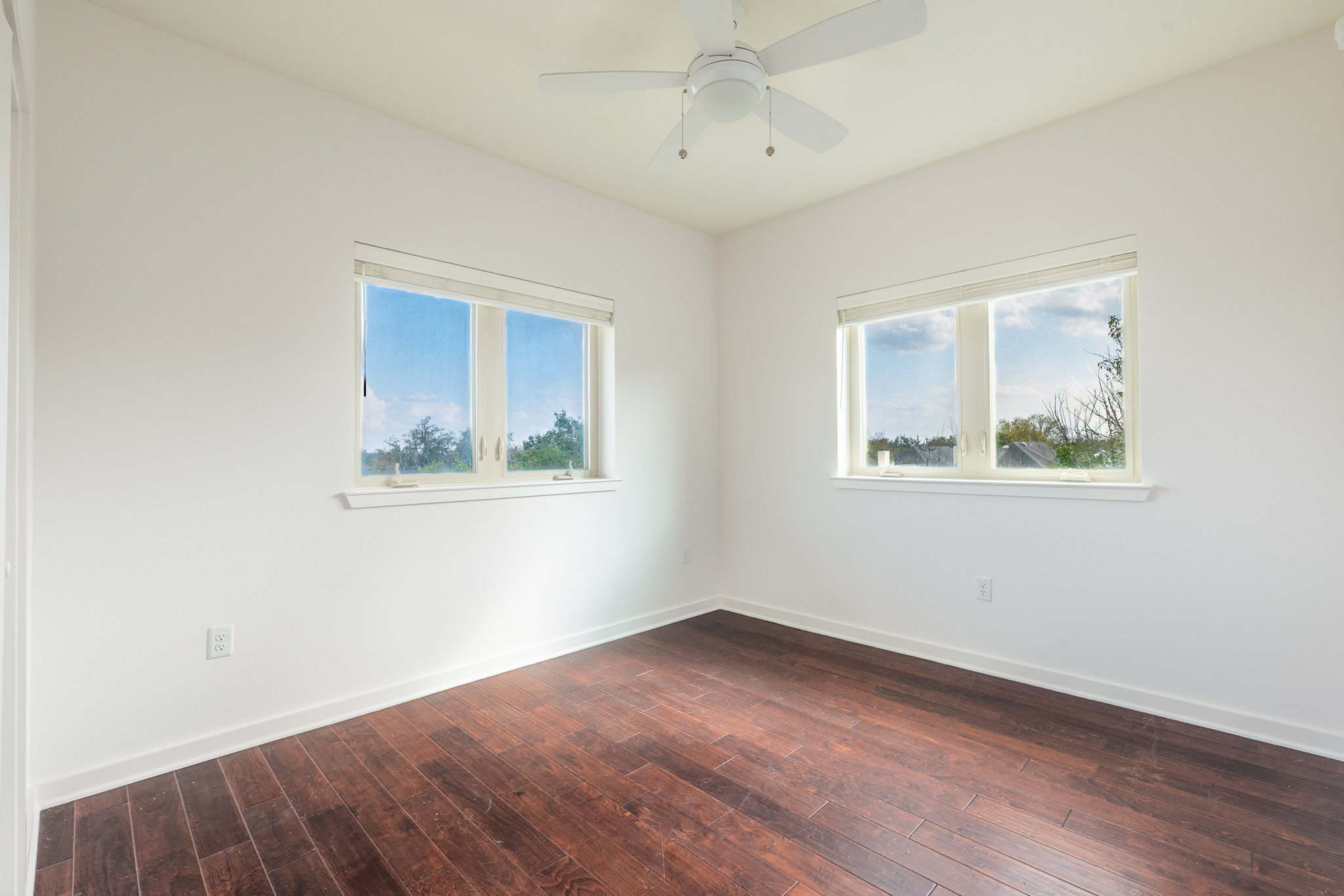 6700 Menchaca Road, Unit 24 Austin, TX 78745 - Photo 10 of 18 Unfurnished room with dark wood-style flooring, healthy amount of natural light, and ceiling fan